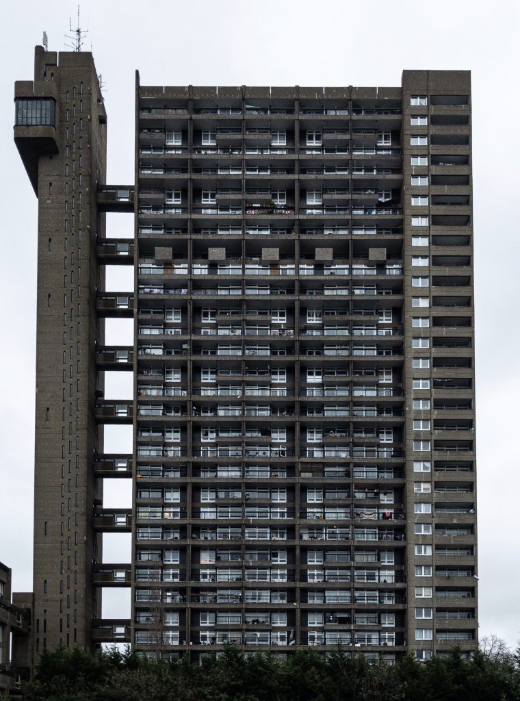 A arquitetura brutalista traz edifícios imponentes, porém, nem sempre despertam de imediato a paixão de todas as pessoas devido a suas formas mais pesadas e sem adornos. Suas características têm a ver com o momento social e econômico vivido por diversos países onde esse estilo arquitetônico floresceu. Conheça mais aqui. Brutalismo: arquitetura marcada pela hora da reconstrução O termo brutalismo surgiu do francês berton brut, que significa concreto bruto. Derivado da arquitetura moderna, a arquitetura brutalista esteve em alta entre os anos de 1950 e 1980, muito popular em projetos arquitetônicos institucionais, como escolas, órgãos públicos e também em projetos habitacionais. O estilo mais “bruto” sem acabamentos ou elementos decorativos nasceu justamente em um período de reconstrução das cidades dos países europeus após a Segunda Guerra Mundial. Portanto, na Europa Central e Oriental há muitos exemplos de edificações do estilo. Em total contraposição ao estilo ornamental criado na arquitetura antes da guerra, a ênfase era focar nos elementos funcionais das edificações ao invés de valorizar suas características estéticas. A aposta era em mais simplicidade e praticidade, com aplicação de materiais mais baratos e resistentes. Além disso, a necessidade também apontava para projetos que pudessem ser construídos rapidamente, com materiais fáceis de obter, por isso, o concreto entrou em cena. É interessante pensar que estava muito longe de existir a plataforma BIM, que permite construções mais rápidas e econômicas. Entre as características das obras da arquitetura brutalista, estão edificações com estilo geométrico, sem adornos, em blocos maciços na forma monolítica e com elementos modulares repetidos. Além disso, a paleta é predominantemente monocromática. É bastante comum que o brutalismo na arquitetura apresente estruturas suspensas, janelas que mais parecem buracos na parede e recortes bastante diferenciados e um tanto singulares. Nesse estilo de edificação, não há um compromisso em esconder os elementos da estrutura da obra, como vigas ou pilares. Mais tarde, a exposição desses elementos no estilo industrial ganhou certo charme. Porém, na arquitetura brutalista esses elementos não têm qualquer verniz estético. Com o tempo, esse estilo de arquitetura começou a ser considerado um estilo meio desajeitado, que muitos profissionais do setor fizeram questão de abandonar. Embora, seus defensores ainda costumem amar o estilo arquitetônico cru e áspero. Arquitetura brutalista brasileira internacional: obras marcantes Bem ao estilo ame ou odeie, há diversas edificações imponentes ao redor do mundo caracterizadas como brutalistas além da Europa, há exemplos também nos Estados Unidos, Canadá, Austrália, Japão e Israel. Apesar de o Brasil não ter sido um território de guerra, o estilo também influenciou a arquitetura do país, com diversos projetos concebidos com as características típicas em São Paulo e no Rio de Janeiro. Apesar da relevância da arquitetura brutalista para o contexto histórico, nos últimos anos, algumas obras brutalistas começaram a ser destruídas, como o edifício Robin Hood Gardens, em Londres, que tinha uma estrutura maciça de concreto, com 213 apartamentos. Vamos conhecer algumas delas no Brasil e no mundo: 1 - Unité d’Habitation (França) Renomado internacionalmente, o arquiteto e urbanista Le Corbusier foi quem consolidou o estilo a partir do projeto Unité d’Habitation, na França, iniciado em 1947 e concluído em 1952. Corbusier era um verdadeiro apaixonado pelas possibilidades do concreto e motivado pelas necessidades de moradia do pós-Guerra, Corbusier concebeu esse edifício como uma cidade-jardim vertical com capacidade para unidades independentes para 1.600 residentes . 2 - Trellick Tower (Inglaterra) Situada em Londres, a torre foi concluída em 1972, com um grande bloco com 31 andares. A estrutura de concreto foi concebida com 100 metros de altura, com elevadores e escadas separadas dos apartamentos. Passou por várias reformas, mas foi classificado como Grade II pelo patrimônio inglês. Sofreu um grande incêndio em 2017, mas ainda é um dos grandes exemplos de arquitetura brutalista no cenário londrino. 3 - The Barbican (Inglaterra) Também situado em Londres, o complexo habitacional moderno The Barbican foi projetado após um ataque aéreo no coração do distrito financeiro da capital. Onde só havia escombros, surgiram 2.000 apartamentos para abrigar trabalhadores, escolas, cinema e restaurante. Além do concreto como protagonista, muitos apartamentos ainda têm cozinhas originais com superfícies em aço inoxidável e banheiros com pias de mão. 4 - Western City Gate (Sérvia) Essa edificação em Belgrado é composta por duas torres de concreto ligadas no topo por uma ponte de dois andares. A aspereza do concreto monumental neste arranha-céu dá uma aparência de edificações vistas em produções de ficção científica. Na verdade, essa é uma característica que faz parte de Belgrado como um todo. 5 - Habitat 67 (Canadá) Situado em Montreal, o Habitat 67 também foi uma solução habitacional conceitual para resolver a questão das moradias. O edifício foi concebido com mais de 350 módulos iguais em concreto, que foram dispostos de uma forma diferente, que resultou em uma formação de 12 andares, edificados de uma forma suspensa que dá a impressão de uma brincadeira de montar do jogo de Lego. Wikimedia Commons 6 - Edificio J. Edgar Hoover (FBI - Chicago) Entre alguns exemplos de obras poderosas marcadas pelo estilo brutalista estão o edifício J. Edgar Hoover, conhecido por ser o quartel-general do FBI, em Chicago (EUA), projetado na década de 1960. No entanto, com o tempo, esse prédio maciço e monumental passou a ser pouco apreciado pelos milhares de funcionários e a mudança do FBI de casa começou a tomar conta dos noticiários. 7 - Prefeitura de Boston (EUA) Diante do declínio econômico do pós-Guerra, o edifício monumental da Prefeitura de Boston também foi concebido na década de 1960. O prédio, projetado por Gerhard Kallmann e Michael McKinnell, recebeu grande influência do estilo de Le Corbusier, apresenta módulos angulares e salientes, e tem fachada em estilo de grade. 8 - Tribunal de Contas do Município de São Paulo (SP) A arquitetura brutalista paulista tem exemplos de edificações expressivas como o Tribunal de Contas do Município de São Paulo. Reserva todas as características próprio da arquitetura, inclusive os recortes singulares. O edifício quadrado, edificado com concreto armado aparente, tem 3 pavimentos e é sustentado por colunas ocas. 9 - Sesc Pompeia (São Paulo) O Sesc Pompeia (São Paulo -SP) é um exemplo de arquitetura brutalista no Brasil. Foi a arquiteta Lina Bo Bardi a encarregada de transformar uma fábrica de tambores em um complexo cultural. O prédio apresenta grandes estruturas em concreto, com paredes sem acabamento, com materiais simples, apenas jateadas com areia. Além disso, suas torres de concreto rígido são ligadas por passarelas aéreas e entrecruzadas. Na concha externa, a antiga estrutura de madeira da ex-fábrica ainda pode ser visualizada. 10 - Prédio da FAU/USP O prédio da Faculdade de Arquitetura e Urbanismo da Universidade de São Paulo (FAU/USP) também foi concebido no estilo brutalista. O prédio traz concreto bruto, vidro e linhas simples, com ênfase em integração de espaços e funcionalidade. O prédio é sustentado por pilares, que são levemente apoiados no chão, e têm forma de trapézios. Não há portas de entrada para marcar a grande liberdade de movimentação da instituição universitária. 11 - MASP (SP) O Museu de Arte de São Paulo (MASP) traz a edificação monumental em concreto, o minimalismo nos detalhes, os recortes singulares, o vão livre e a estrutura suspensa como um dos prédios mais marcantes da arquitetura brutalista paulista. 12 - MAM (RJ) Apesar do estabelecimento da arquitetura brutalista em São Paulo, o Museu de Arte Moderna do Rio de Janeiro foi onde esse estilo teve seu início no Brasil. O MAM foi a primeira obra de concreto aparente do país. Lá estão presentes, o concreto, as grandes janelas com vidro e as colunas monumentais. O projeto é de Affonso Eduardo Reidy.